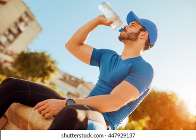 Thirsty Man Having A Break Drinking A Bottle Of Water.