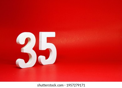 Thirty Five ( 35 ) white number wooden Isolated Red Background with Copy Space - New promotion 35% Percentage Business finance Concept 