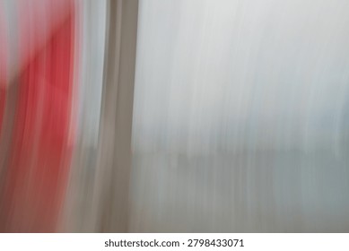 This abstract composition captures a dynamic interplay of light, color, and motion, heavily utilizing the intentional camera movement (ICM) technique to blur the lines between reality and minimalist art. On the left side of the frame, a vibrant, saturated streak of crimson and soft pink bleeds vertically, suggesting a rapid panning motion against a solid structure or a sudden burst of light. This vivid column of warm tones contrasts sharply with a thick, vertical dividing line of muted cream and soft beige, which acts as a visual anchor in the composition. The remaining two-thirds of the image open up into a vast, ethereal expanse of textured whites, cool grays, and subtle undertones of slate blue. The vertical motion blur creates a fine, corduroy-like texture across the lighter canvas, giving the illusion of a translucent curtain, frosted glass, or an urban landscape viewed through a rain-streaked window at high speed. The overall mood is avant-garde and atmospheric, evoking a sense of fleeting time, architectural minimalism, and emotional transition. It functions perfectly as a high-end contemporary background or conceptual fine-art piece.