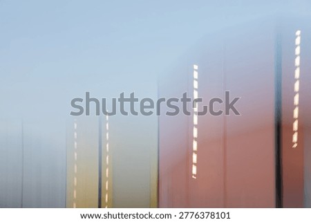 This abstract ICM (Intentional Camera Movement) image features a series of vertical, rectangular forms captured with a motion blur effect that softens their edges and blends their colours. The palette transitions from warm, earthy terracotta and ochre tones on the right to cool, muted blue and grey hues on the left. Streaks of light punctuate the vertical columns, creating a sense of upward movement or a passing cityscape seen through a moving window. The composition is minimalist and ethereal, stripping away fine detail to focus on light, color, and vertical rhythm.

Mood
The mood is tranquil, contemplative, and sophisticated. The soft focus and gentle color gradients evoke a feeling of dreamlike serenity or the quiet rush of urban life at dusk. It feels modern and polished yet remains deeply atmospheric and calm.

Suggested Usage
This versatile abstract can be used in various professional and creative contexts:
Interior Design: As large-scale wall art for modern offices, hotel lobbies, or minimalist living spaces.
Web Design: A sleek, non-distracting background for corporate websites, landing pages, or digital portfolios.
Editorial: Background imagery for articles focusing on architecture, urban planning, or mental wellness.
Branding: A stylish visual element for presentation slides, brochure covers, or social media graphics.