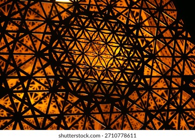 This abstract image features a complex geometric pattern illuminated by a warm, inviting light source