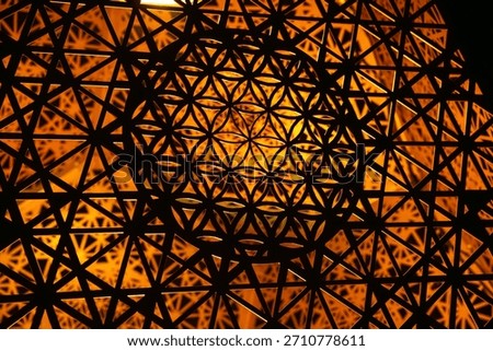 This abstract image features a complex geometric pattern illuminated by a warm, inviting light source