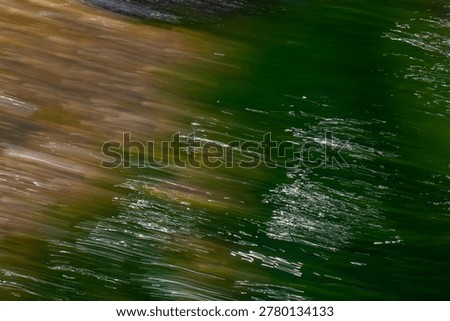 This abstract image features an intentional camera movement (ICM) technique that captures a dynamic, painterly blend of deep forest green and earthy ochre tones. The composition is defined by sharp, diagonal light streaks that mimic the shimmering reflection of sunlight on a moving water surface or wind-swept foliage.

Mood: The mood is energetic yet contemplative, blending the organic tranquility of nature with a sense of rapid, fluid motion.

Usage: This versatile abstract is ideal for contemporary interior decor as a large-scale wall art piece or as a textured background for digital media, wellness branding, and editorial layouts focusing on environmental themes or artistic expression.