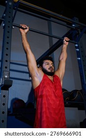 This active young man with a beard is focused on his indoor workout routine at the gym.