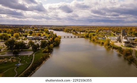 This aerial photo showcases downtown Saginaw, Michigan on a cloudy fall day with the colorful foliage lining the Saginaw River and bridges weaving through the heart of the city. Oct 15, 2022 - Shutterstock ID 2292106355