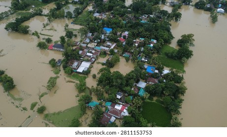 This aerial photograph captures the devastating impact of flooding in Bangladesh, where rising floodwaters have submerged roads, homes, and surrounding farmland, disrupting daily life for thousands of people.