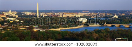 This is an aerial view of Washington, DC. The Potomac River runs through the center with the Key Bridge at right at sunset.