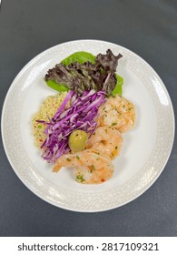 This appears to be a cold prawn appetizer salad plated in a finedining or airline catering style.
