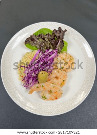 This appears to be a cold prawn appetizer salad plated in a finedining or airline catering style.