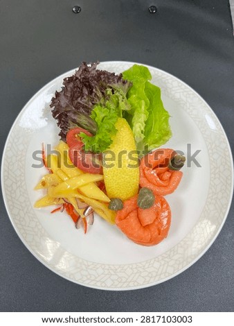 This appears to be a cold smoked salmon appetizer salad plated in a finedining or airline catering style.