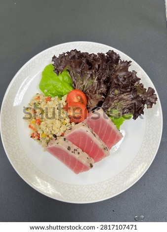 This appears to be a cold tuna tataki appetiser salad plated in a finedining or airline catering style