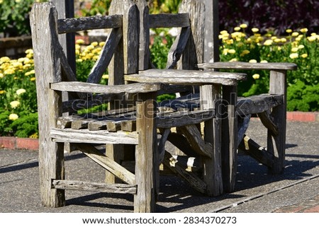 This appears to be a rustic, handmade double garden seat or companion chair crafted from weathered timber battens and posts.