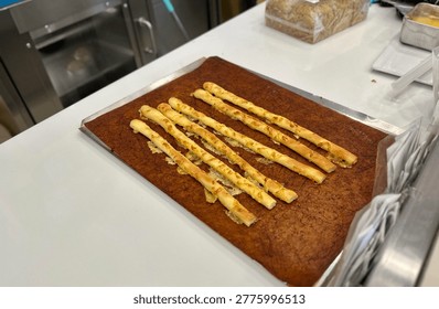 This appetizing photograph captures a batch of freshly baked cheese breadsticks resting on a brown silicone baking mat.