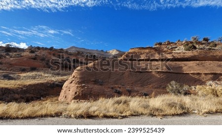 This awe-inspiring red rock mountainside is a natural wonder. The swirls and striations in the rock create a beautiful and majestic landscape.