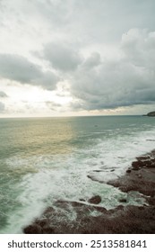 This beach scene features soft sands and gentle waves, creating a tranquil setting where the beauty of the shoreline and the expansive ocean meet in harmony.