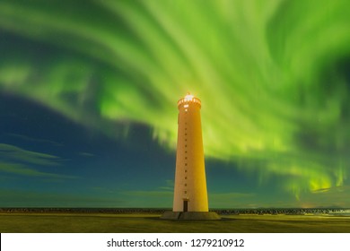 This beautiful northern lights or aurora borealis in Iceland was taken at or around lighthouse near Keflavik during a winter night. Green northern lights. Starry sky with polar lights.