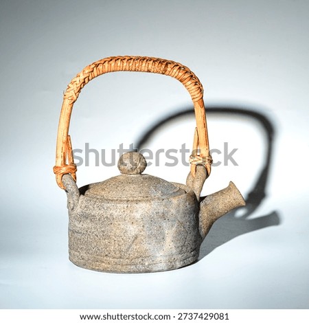 This is a Bizen ware teapot with a handle from Japan. Bizen ware is the foremost of Japan's six ancient kilns, dating back over 1000 years. Its characteristics include its rustic simplicity and lack of glaze.