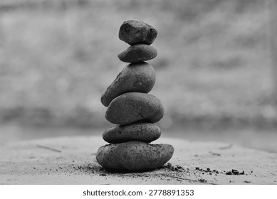 This is a black and white photograph of a stack of smooth stones, often symbolizing balance, tranquility, and Zen.