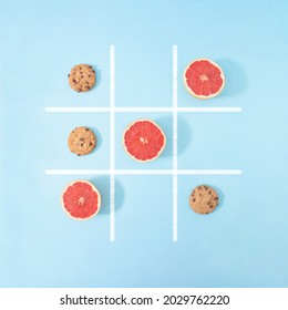 In This Board Game 
Grapefruit Beats Chocolate Chip Cookies, That Means Healthy Food Is Better Than Junk Food, So Win This Game. Creative Flat Lay Concept.