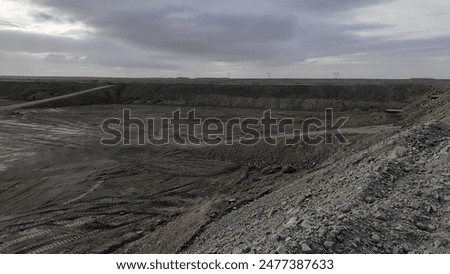 This breathtaking aerial view captures the vastness of a massive open pit, showcasing the impressive scale of human excavation activities. Witness the sheer magnitude of this industrial marvel.