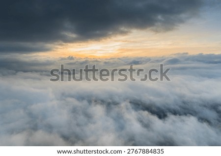 This breathtaking drone hyperlapse video showcases a golden sunrise over a thick sea of ​​clouds and swirling fog. The serene mountain landscape at dawn, the fog-shrouded village – the atmosphere is peaceful, inspiring, and magnificent.