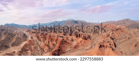 This breathtaking panoramic view captures the stunning red rock canyon nestled in the mountains. The vibrant shades of the rocks and  awe sky