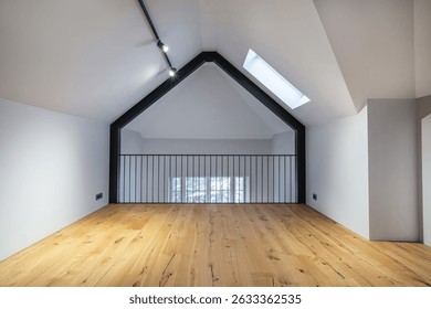 This bright loft features a spacious wooden floor, tall walls, and a prominent skylight allowing natural light to illuminate the space. Ideal for creative projects or relaxation.