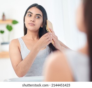 This Brush Is The Key To Bouncy Fullness. Shot Of Young Woman Brushing Her Hair In Front Of The Mirror.