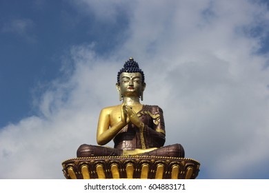 This Buddha Statue Is Situated In Buddha Park In North Sikkim District Of India. Plush Landscape, Ice-clad Mountains In Background And Giant Statue Make This Place A Tourist Attraction.