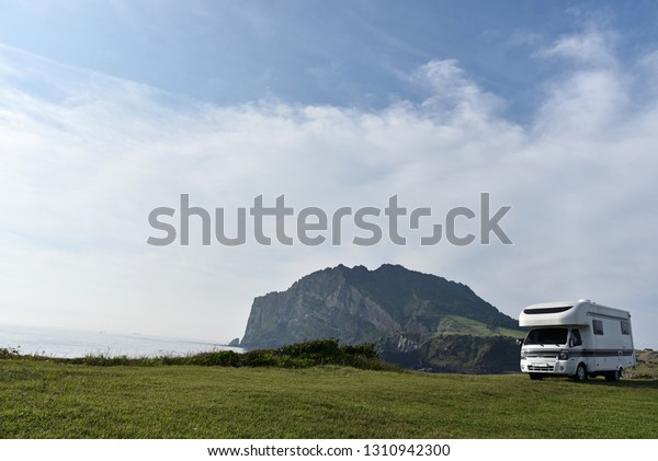 This is a camping car set in Seongsan Ilchulbong\
Peak, Jeju.
