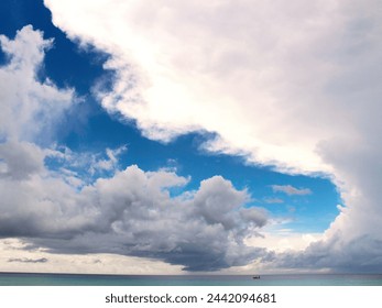 This captivating image depicts a motorboat cruising on a calm ocea, surrounded by clouds.