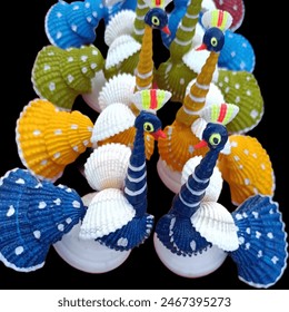 In this captivating image, an exquisite peacock is meticulously crafted from an array of vibrant seashells, showcasing the harmonious blend of nature's beauty and human creativity.