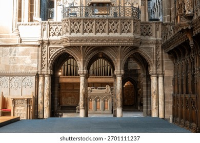 This captivating image reveals the intricate architectural beauty of a historic interior of Chester Cathedral. A grand stone balcony, adorned with elaborate carvings and a wrought-iron railing.