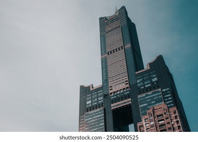 This captivating image showcases the iconic Kaohsiung 85 Sky Tower, a prominent skyscraper in Taiwan. The tower stands tall against a clear sky, highlighting its modern architecture and unique design.