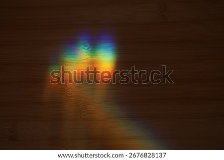 This captivating image showcases a vibrant rainbow prism effect projected a dark wooden surface. For creative projects, abstract art, optical illusions. Red, orange, yellow, green, blue, violet.