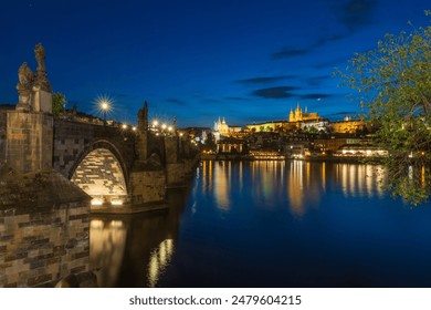 This captivating nighttime photograph of Prague showcases the iconic Charles Bridge and the stunning Prague Castle illuminated against the deep blue twilight sky. - Powered by Shutterstock