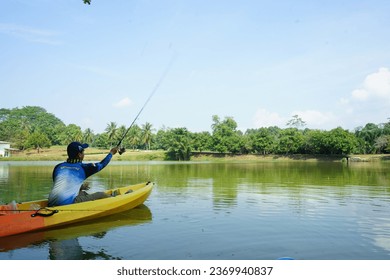 In this captivating photo, the art of fishing takes center stage on a tranquil lake. A solitary angler sits perched on the edge of a small boat, their line cast into the glistening water, waiting for  - Powered by Shutterstock