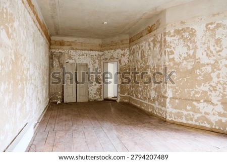 This captures an empty apartment room in an old building in Berlin, Prenzlauer Berg, before renovation. The interior features peeling paint and plaster on the walls.