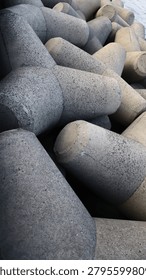 This close-up captures the formidable strength of interlocked concrete tetrapods, forming a resilient coastal breakwater. The rugged, textured blocks underscore their massive structural durability, vital for effective erosion control and wave protection against the ocean. This powerful image is perfect for environmental protection initiatives, marine engineering projects, and highlighting robust coastal tourism infrastructure