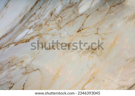This is a close-up image of a white marble texture with gold and brown streaks running through it. The streaks are irregular and scattered throughout the surface.