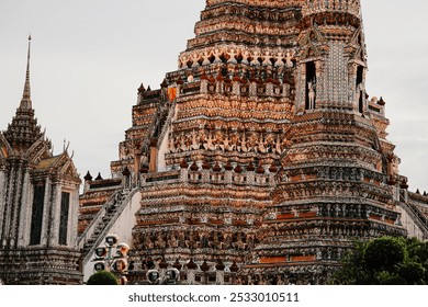 This close-up photograph captures the stunning details of Wat Arun, Bangkok’s largest temple. Its intricate spires, vibrant colors, and ornate carvings reflect Thailand's rich cultural heritage. - Powered by Shutterstock