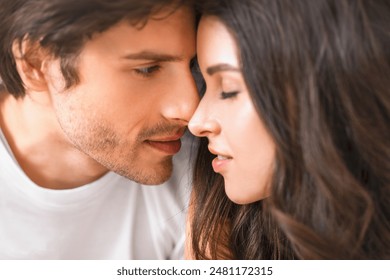 This is a close-up portrait of a man and a woman about to kiss. They are looking into each others eyes and appear to be in love. - Powered by Shutterstock