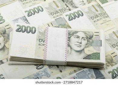 This close-up shot features a bundle of Czech Koruna banknotes, specifically 2000 CZK denominations. Neatly stacked and secured with a paper band, Czech Republic.