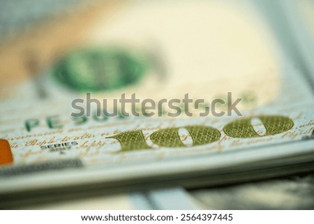 This close-up view captures the complex features of a hundred dollar bill, highlighting its various colors and textures in a detailed presentation.