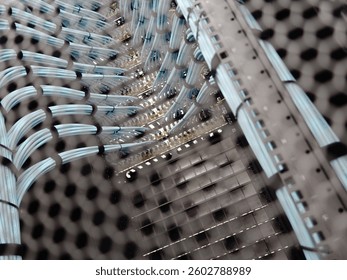 This close-up view showcases a complex network of cables within a data center, highlighting modern infrastructure, organization, and technological connectivity.