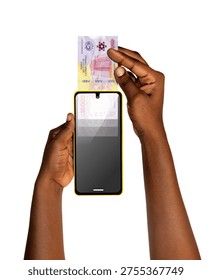 This conceptual image features two hands with dark skin tones against a white background. One hand holds a yellow-bordered smartphone vertically, while the other hand appears to be sliding a Central African CFA franc banknote directly into a slot at the top of the phone. The screen of the device shows a faded, digital reflection of the currency. The visual serves as a powerful metaphor for fintech, mobile money deposits, and the digitization of traditional currency in Central Africa.