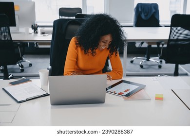 In this contemporary coworking space, a marketing specialist in a bright orange sweater analyzes data trends, crafting her next big campaign. - Powered by Shutterstock