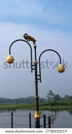 This is a decorative lighting pole featuring a ram sculpture on top, commonly used to enhance urban landscapes or public spaces. 