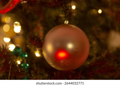 This is a detailed closeup image featuring a beautifully crafted Christmas ornament hanging on a welldecorated tree, adding to the festive cheer