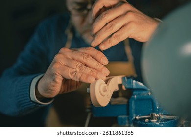 In this detailed view from Cremona, an artisan performs a vertical chisel cut on a violin scroll, wood secured in a vise under lamplight. The intensity and skill are clear in every element.